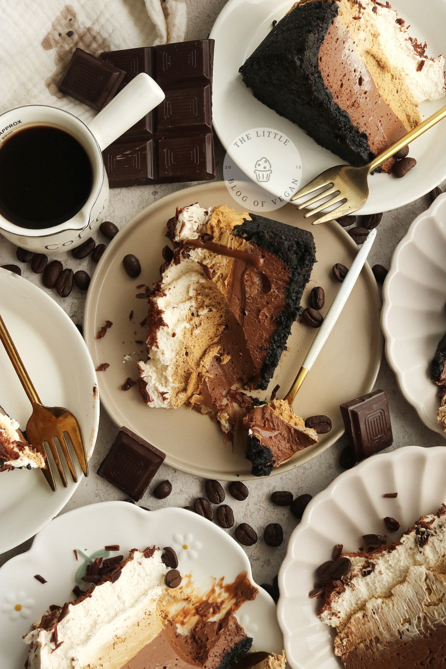 Slices of chocolate espresso dessert served on small plates next to a cup of hot coffee.