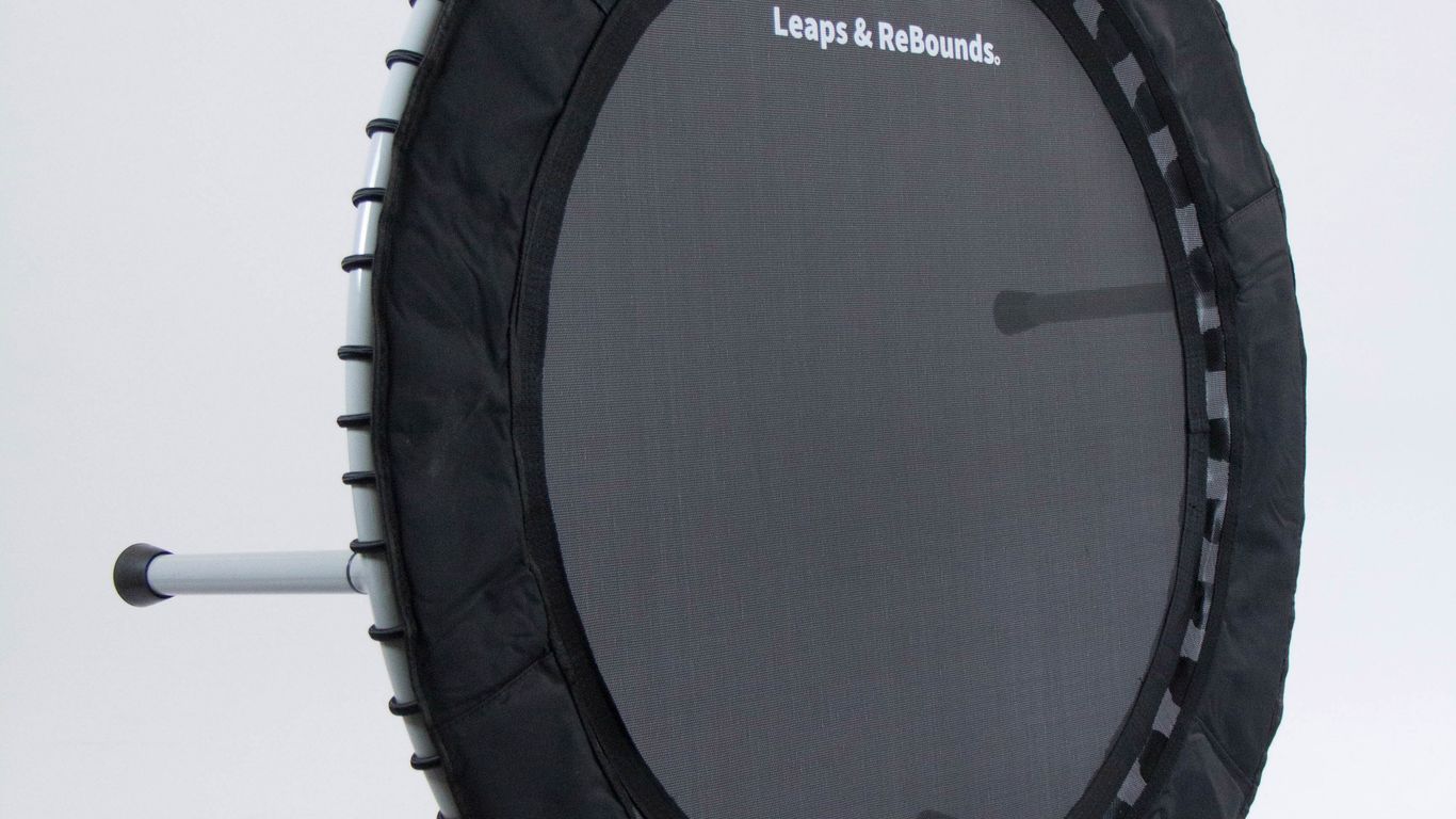 A compact black indoor fitness trampoline used for aerobic conditioning and cardiovascular workouts.