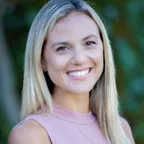 A professional fitness coach or wellness expert smiling in a natural light setting