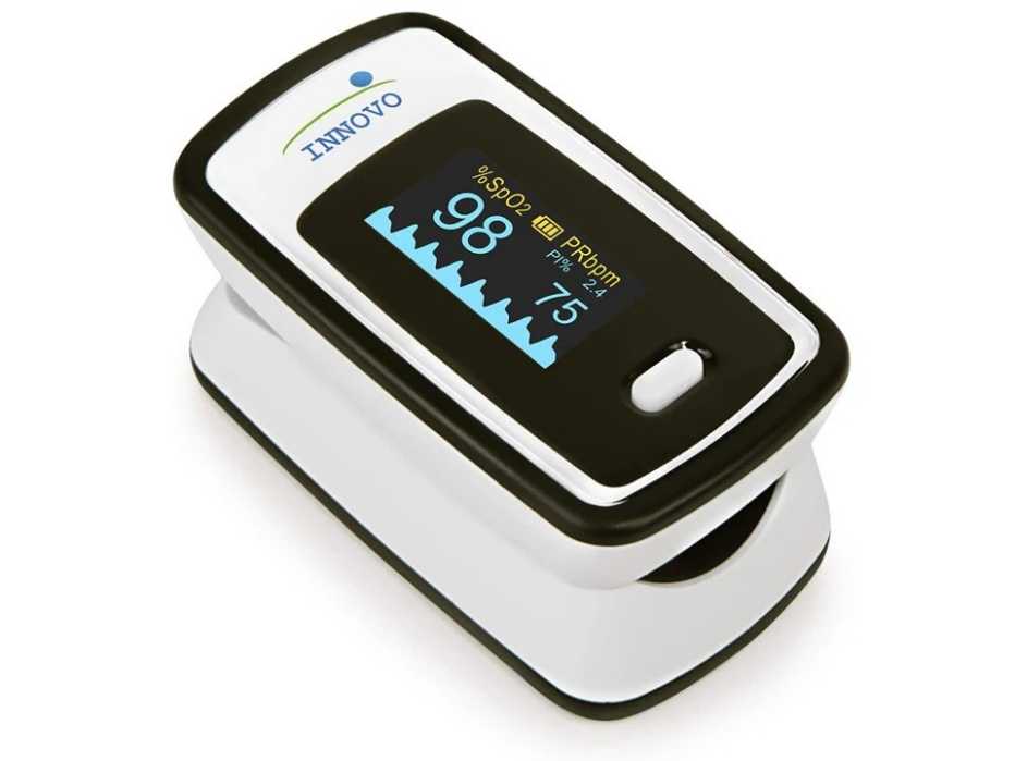 The Innovo Deluxe iP900AP pulse oximeter displaying numerical health data on its screen.