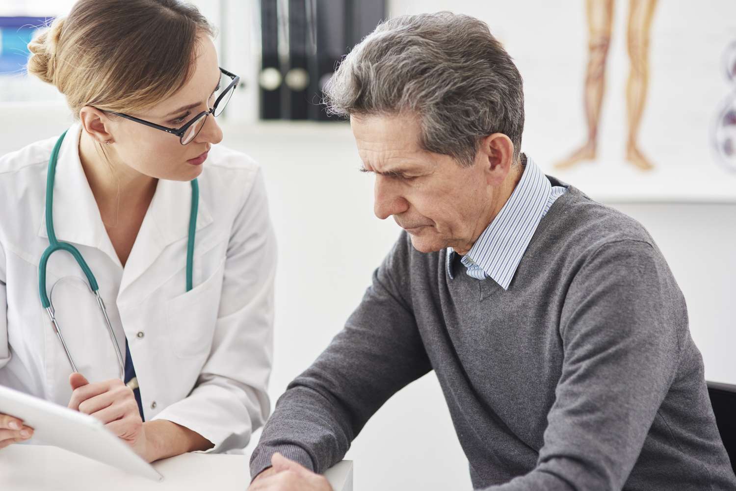 A healthcare professional using a digital tablet to explain sleep health data to a patient in a modern clinic.