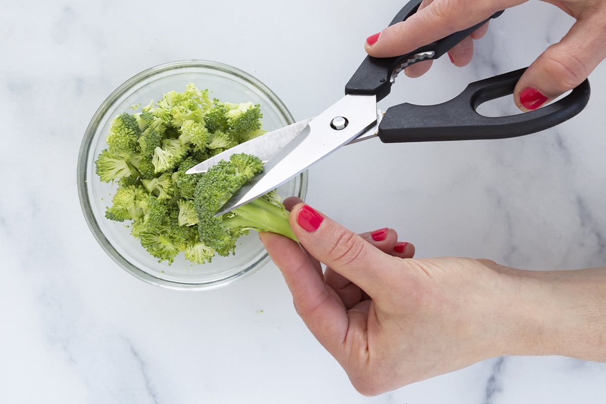 Close-up of fresh green broccoli florets being finely prepared for waffle batter.