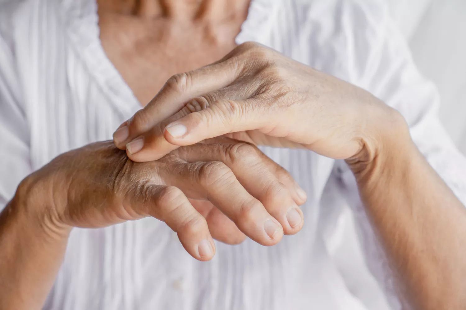 A close-up shot of an elderly person's hand, highlighting the vulnerability of senior patients.