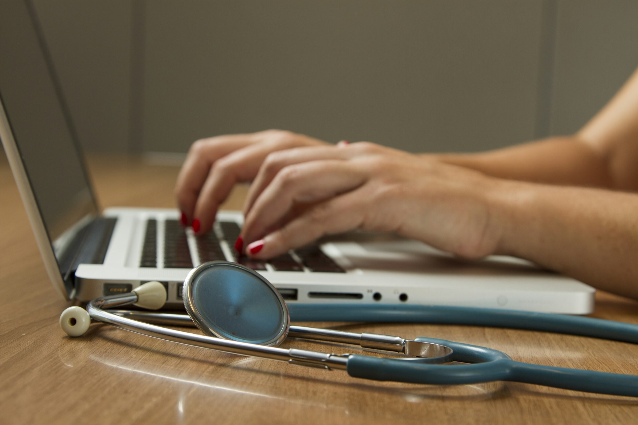 A doctor in a white coat consulting with a patient in a clinical office setting.