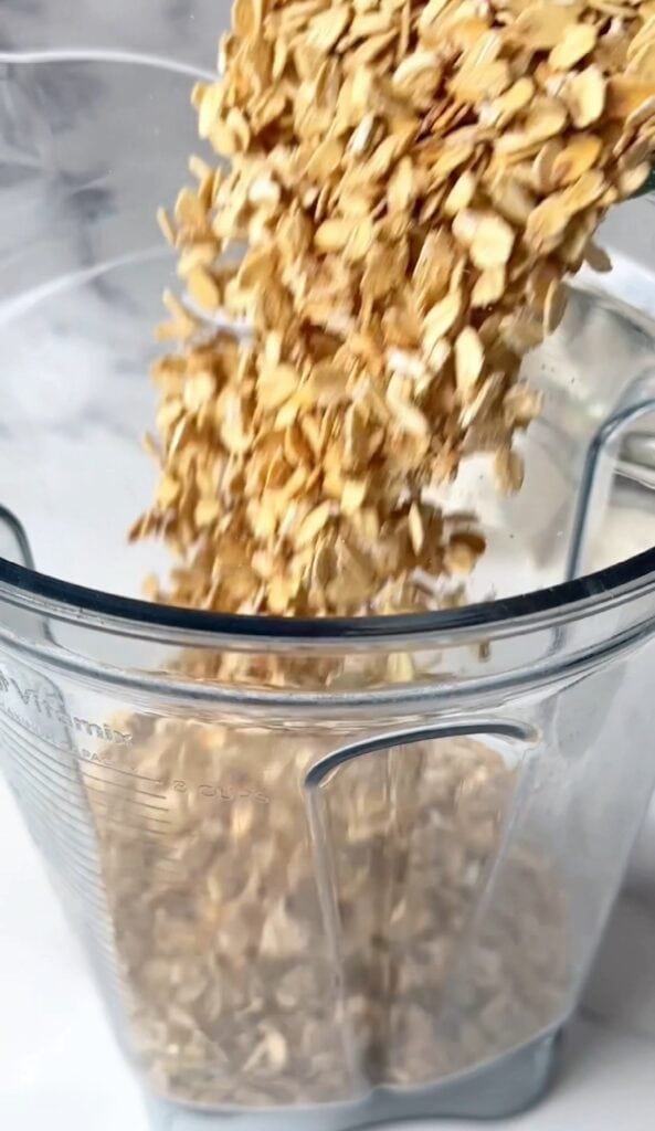 Rolled oats spread across a baking sheet, appearing golden brown after roasting.