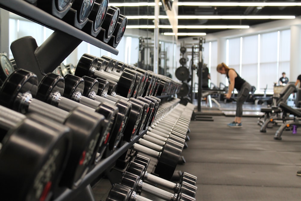 A person lifting heavy dumbbells in a gym setting.