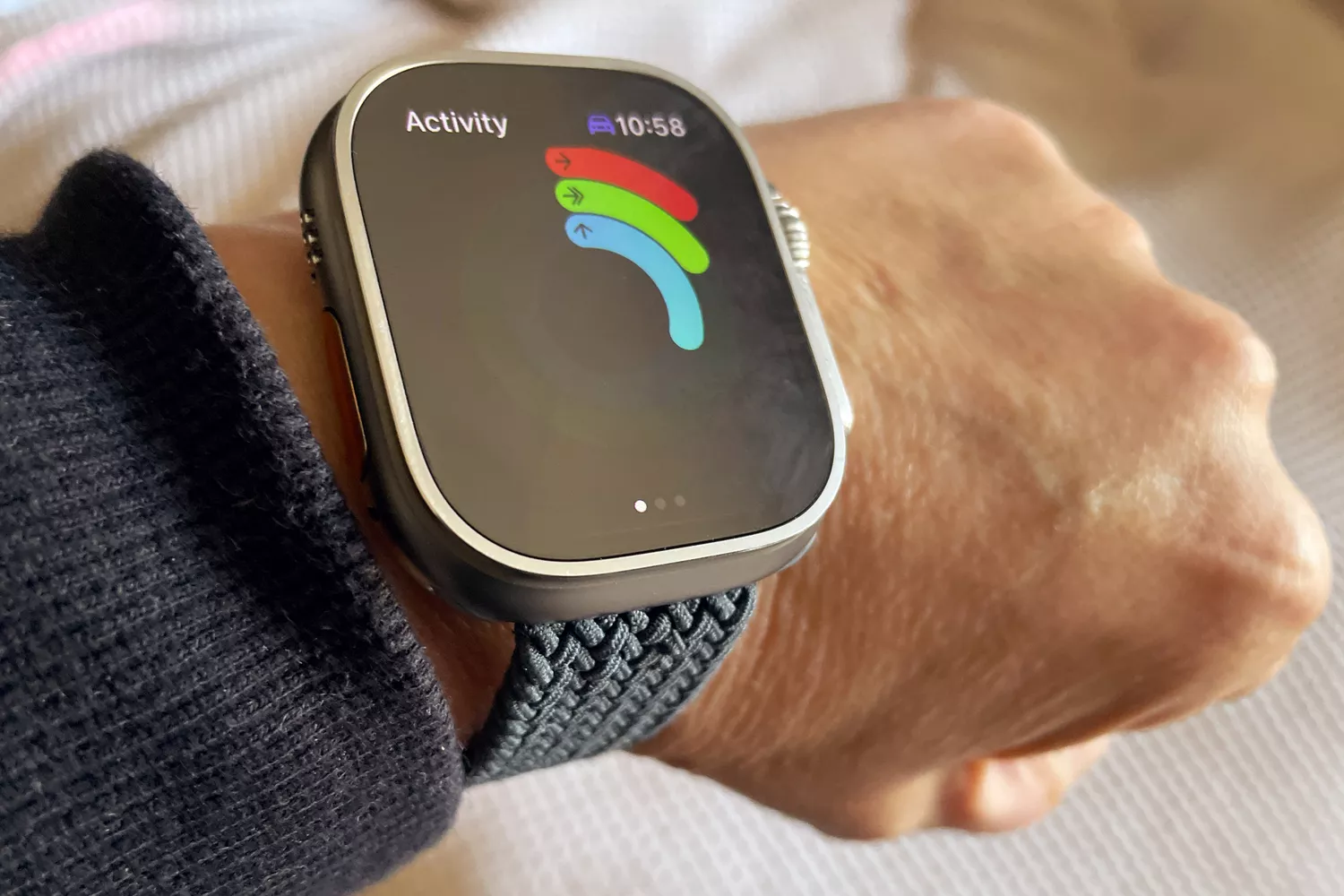 An Apple Watch Ultra displaying the vibrant Activity app rings on the user's wrist.