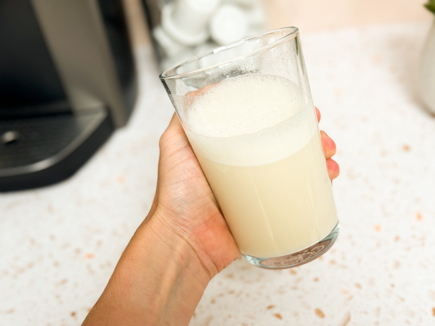 A close-up view of a scoop filled with fine, high-quality white protein powder.