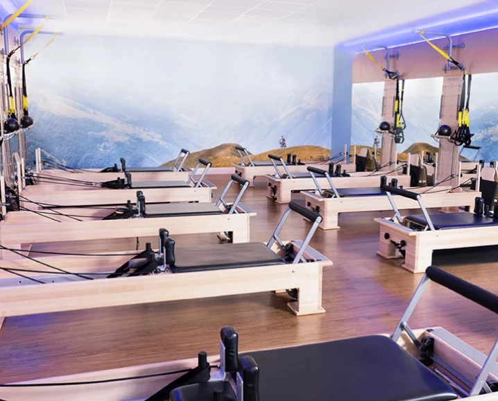 A person practicing functional movement on a Pilates Reformer.