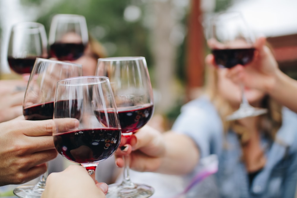 A single glass of red wine on a dark wooden surface.