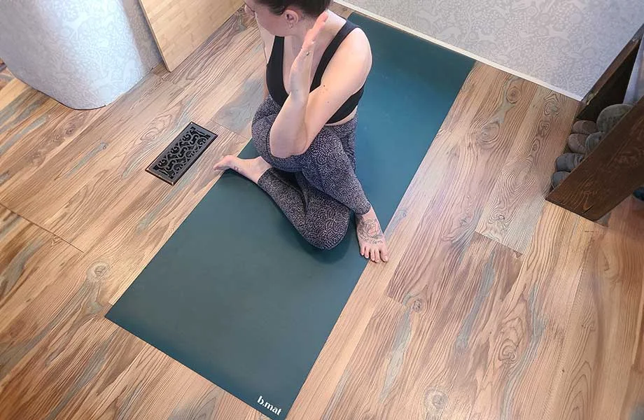 A high-quality yoga mat placed on the floor, ready for an at-home Pilates session.