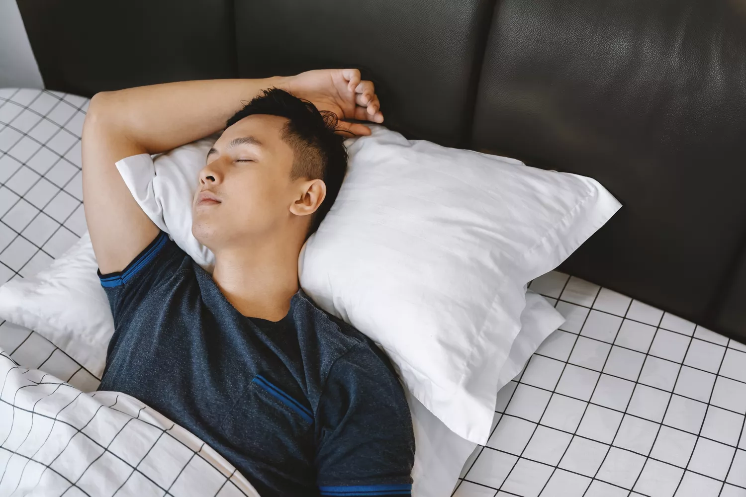 A man sleeping in a bed, representing total physical inactivity.