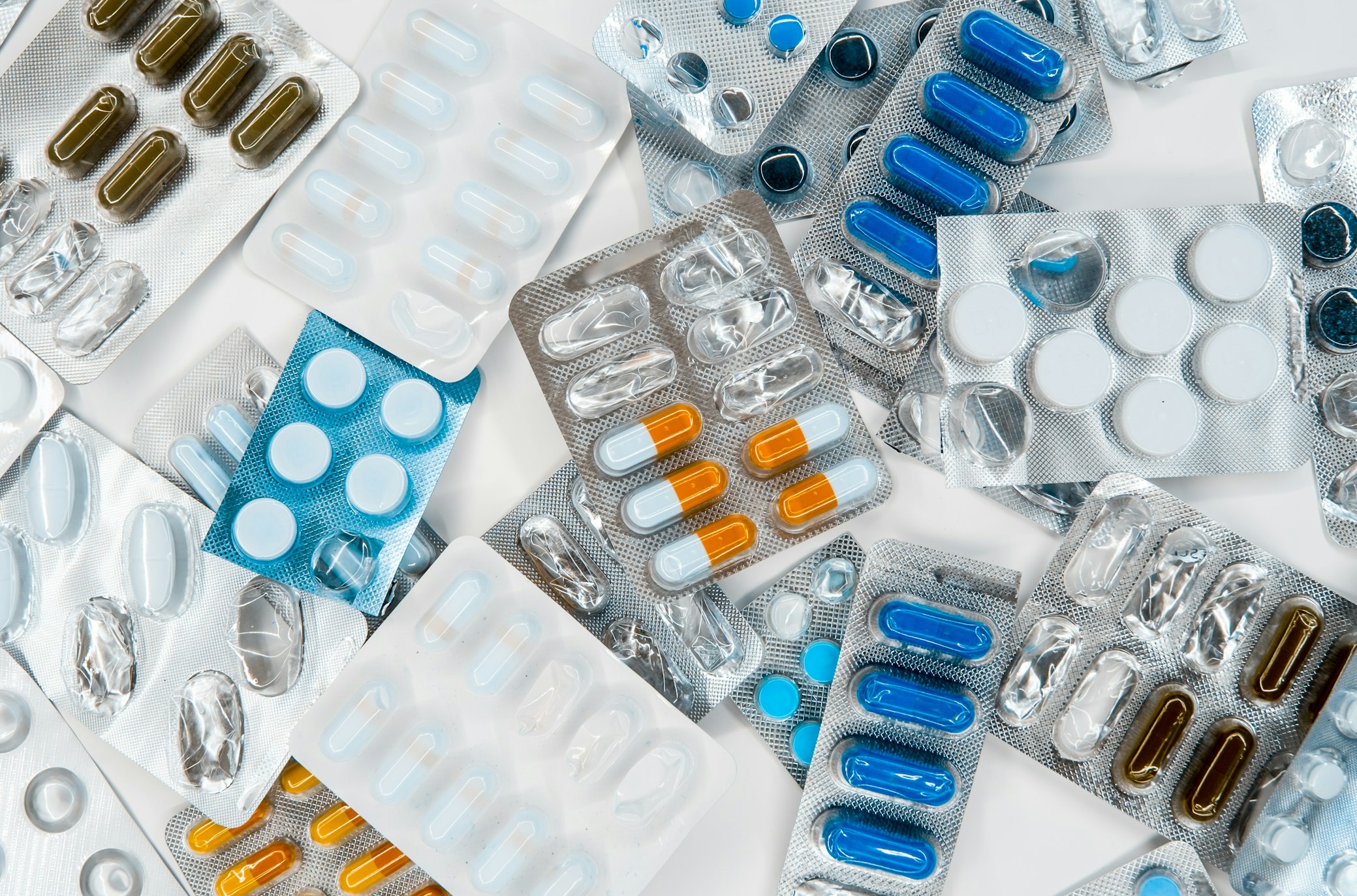 A pharmacist working in a controlled compounding laboratory environment with specialized equipment.