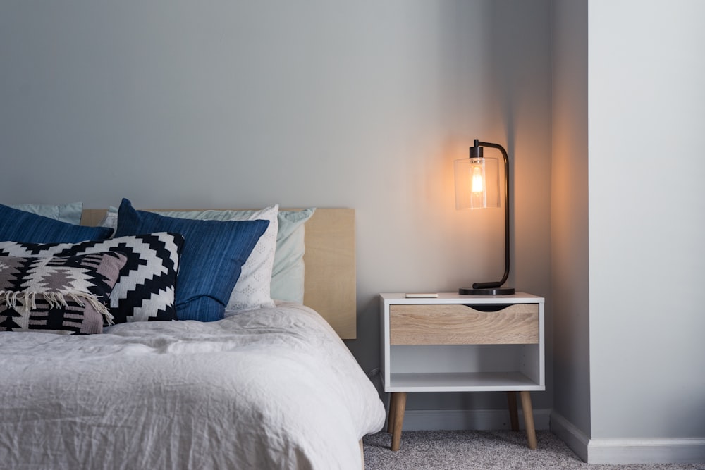 A clean and dark bedroom with minimalist decor and soft textures.