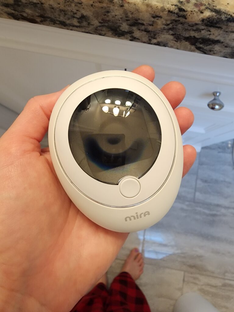 Close-up of the Mira Fertility Tracker device with a digital display.