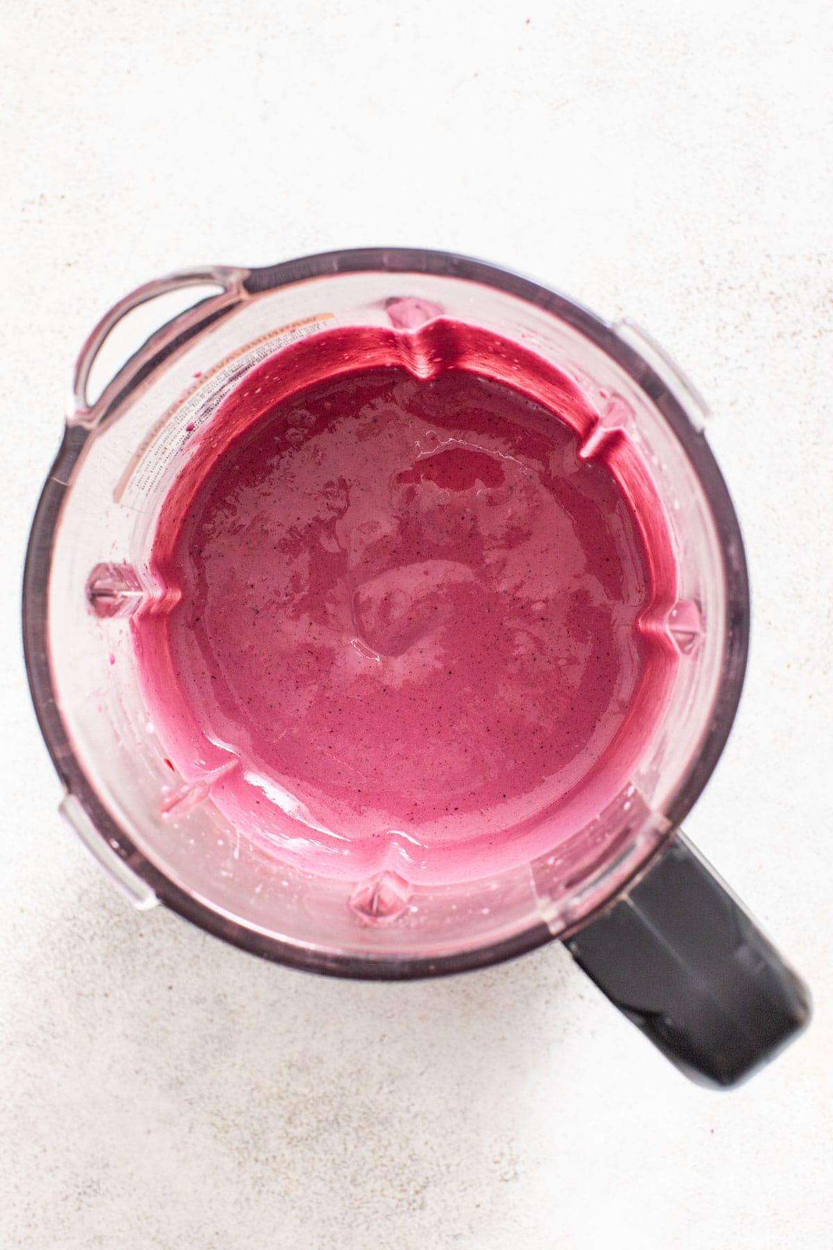 A thick, smoothly blended purple berry mixture in a blender jar.