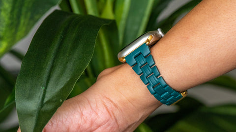 A person wearing an Apple Watch with a woven fabric or nylon strap.
