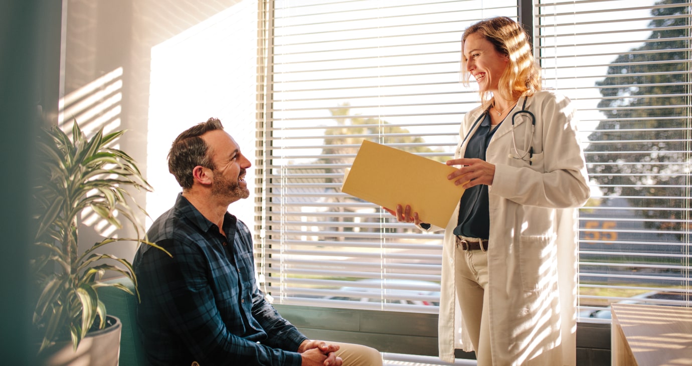 A doctor and patient reviewing digital medical records together on a tablet.