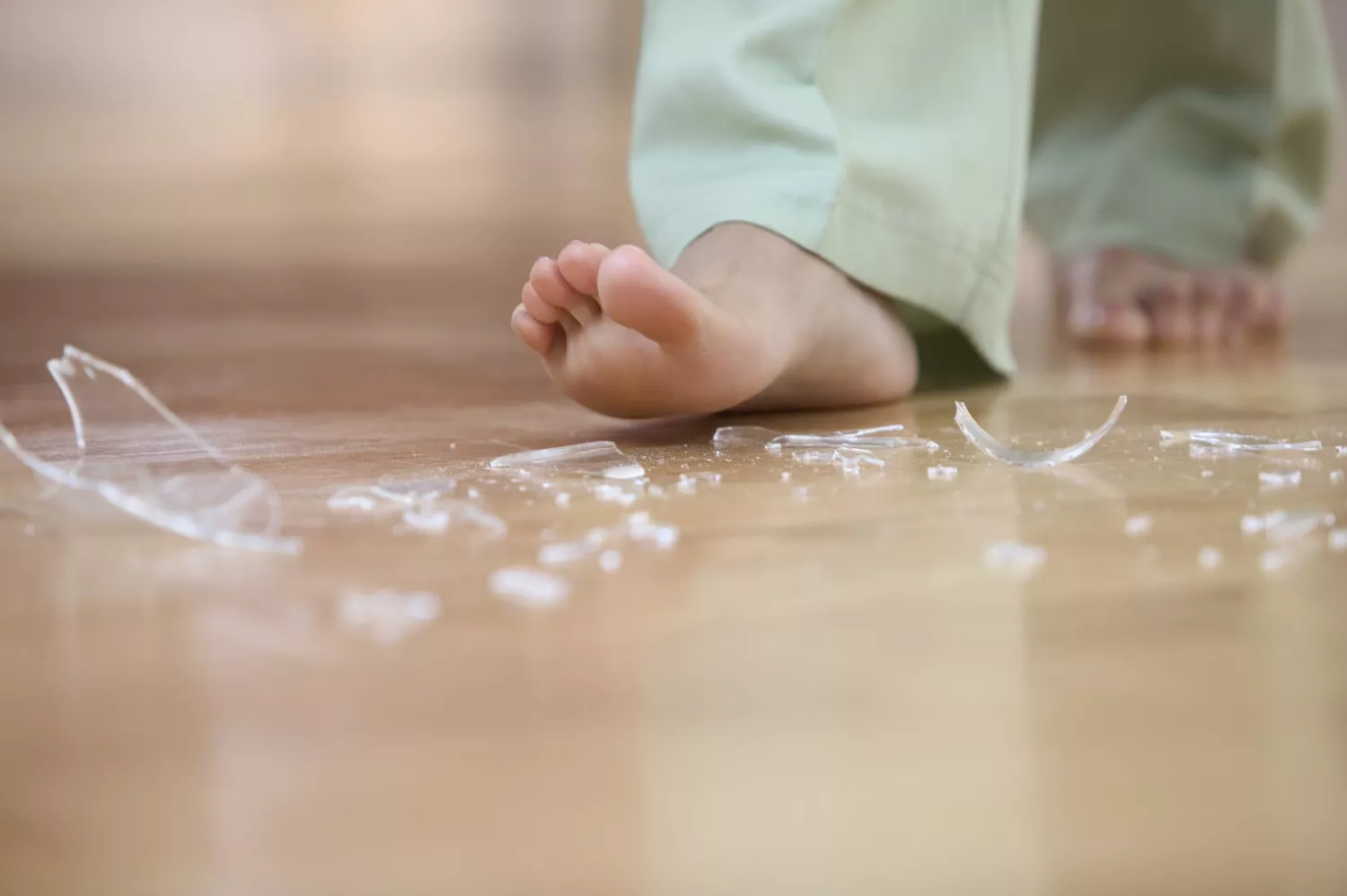 A barefooted person stepping on glass, symbolizing the sharp pain of rheumatoid arthritis.