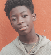 A young man smiling confidently at the camera.