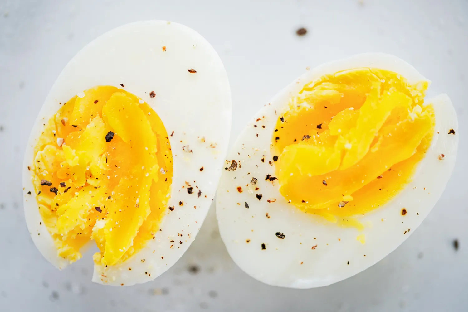 A hard boiled egg cut in half and seasoned with a small amount of salt and pepper.