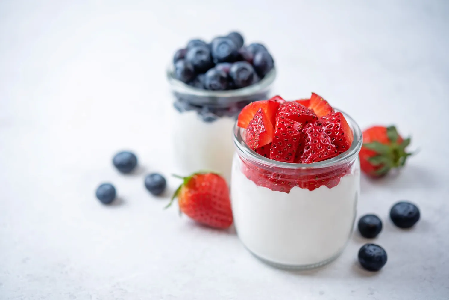 A bowl of Greek yogurt topped with a few fresh berries.