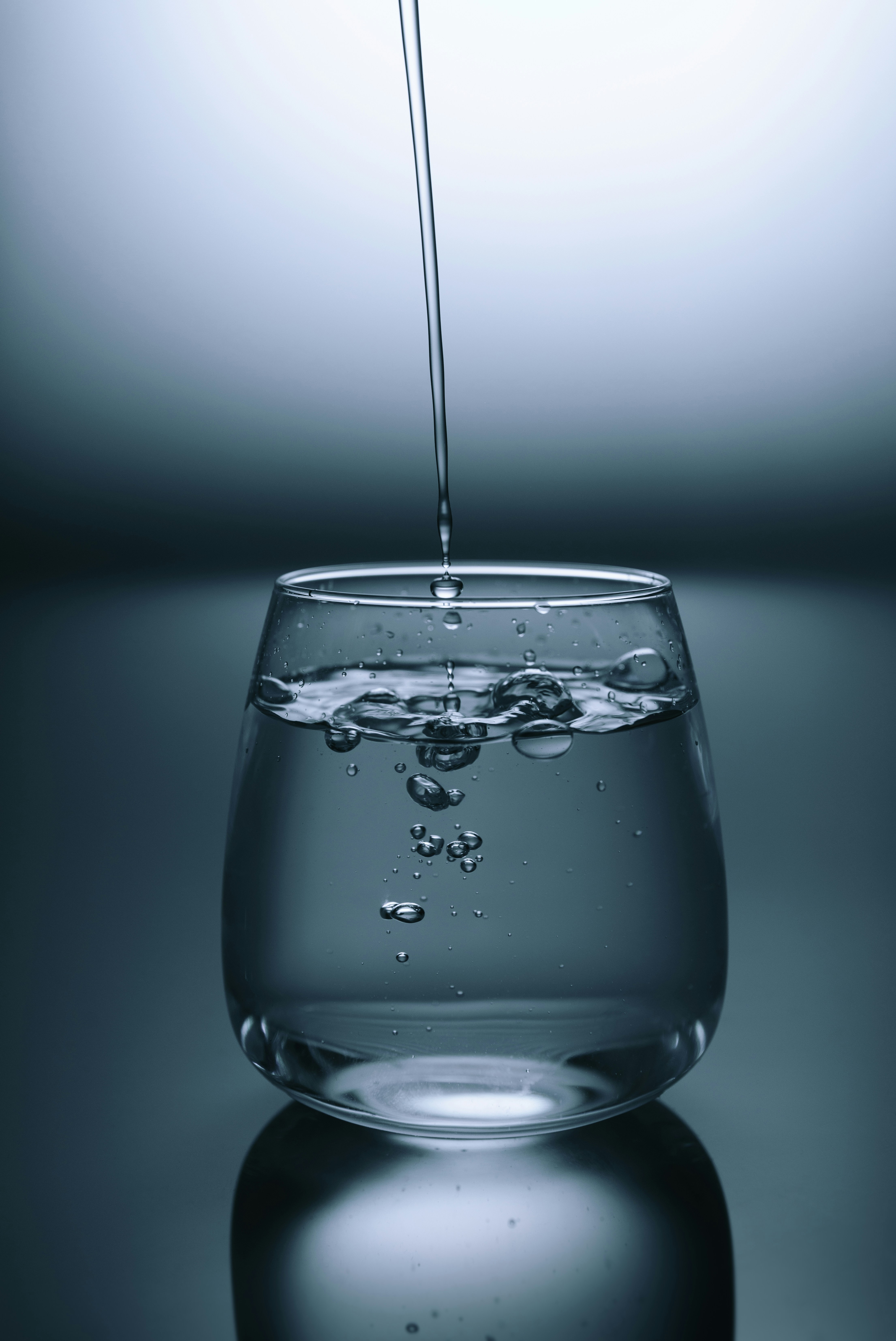 A glass of water with lemon slices on a table.