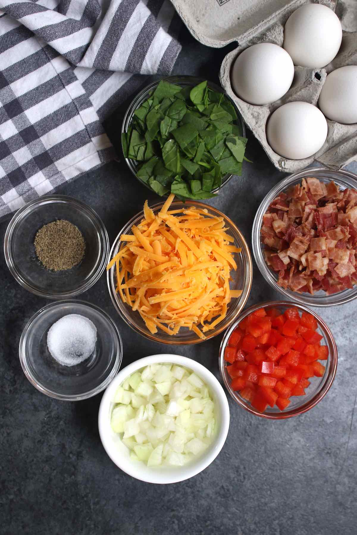 Prepped fresh ingredients including eggs, spinach, and bell peppers on a kitchen counter.