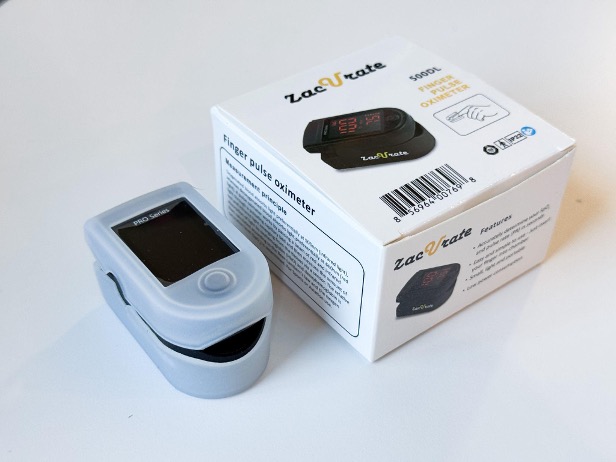 An individual checking their oxygen saturation levels using a Zacurate pulse oximeter at home.