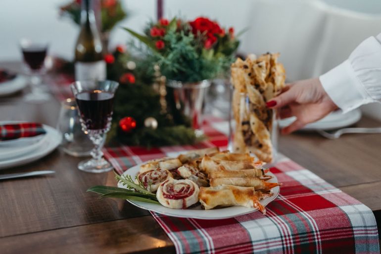 Cozy and festive holiday table setting with plates and decorations.
