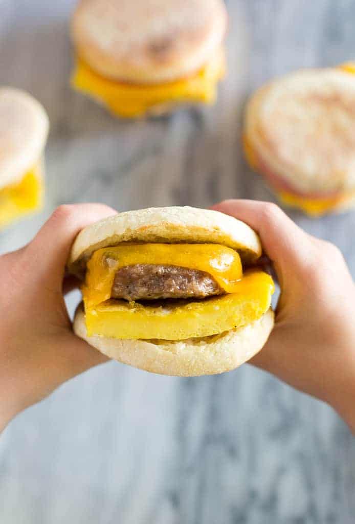 Close-up of hands holding a warm, fiber-rich breakfast muffin ready to eat.