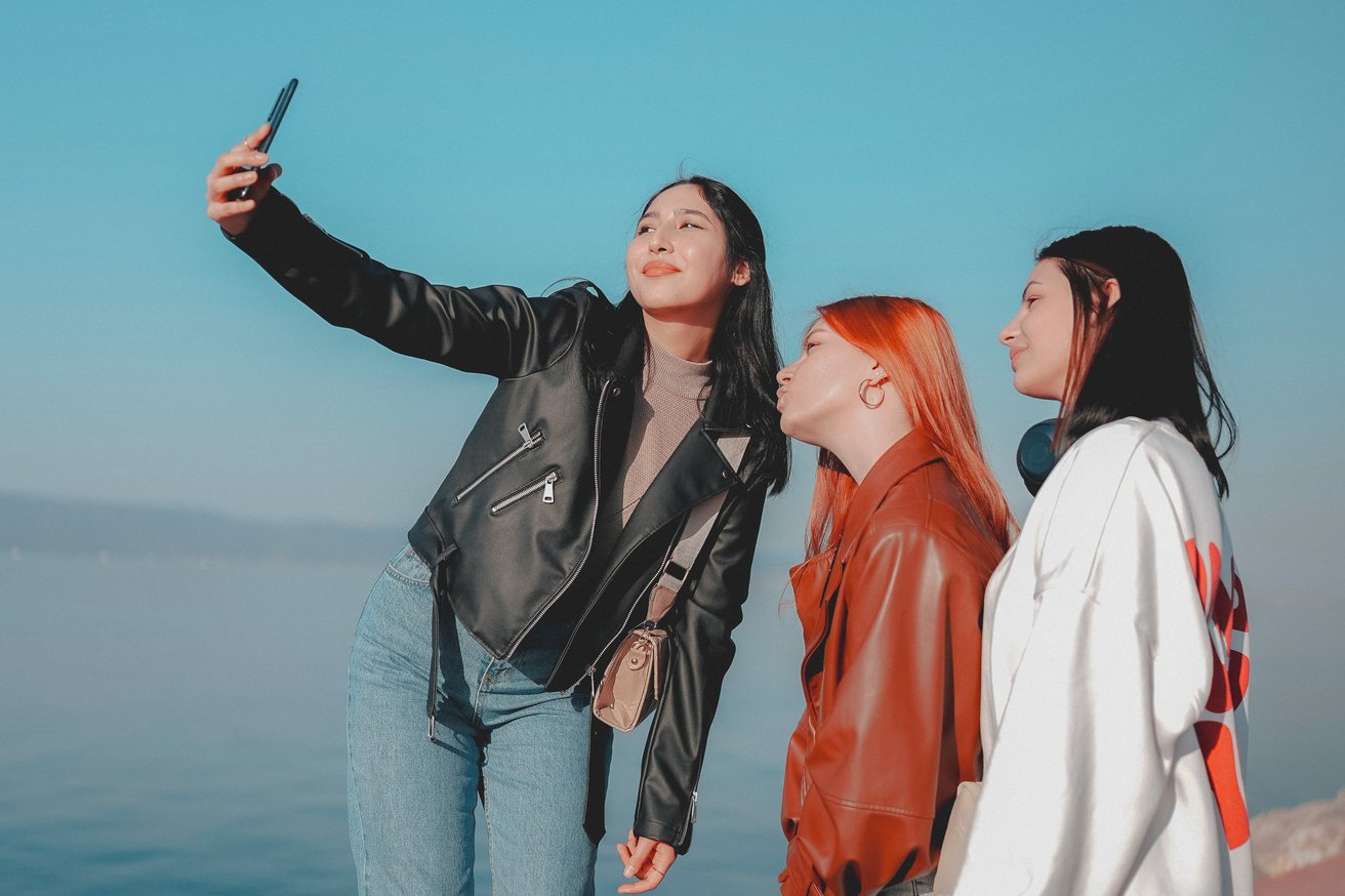 Two teenage girls taking a selfie together with a smartphone.