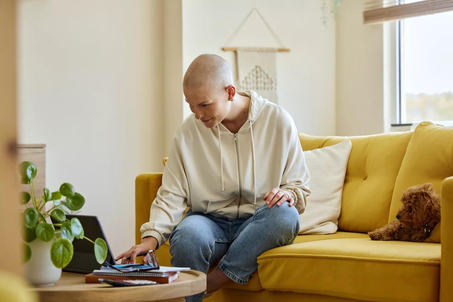 A person sitting at a desk focusing on a laptop while researching metastatic breast cancer support resources.