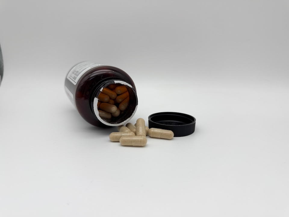 An Innerbody Labs Sleep Support bottle on its side with capsules spilling out.