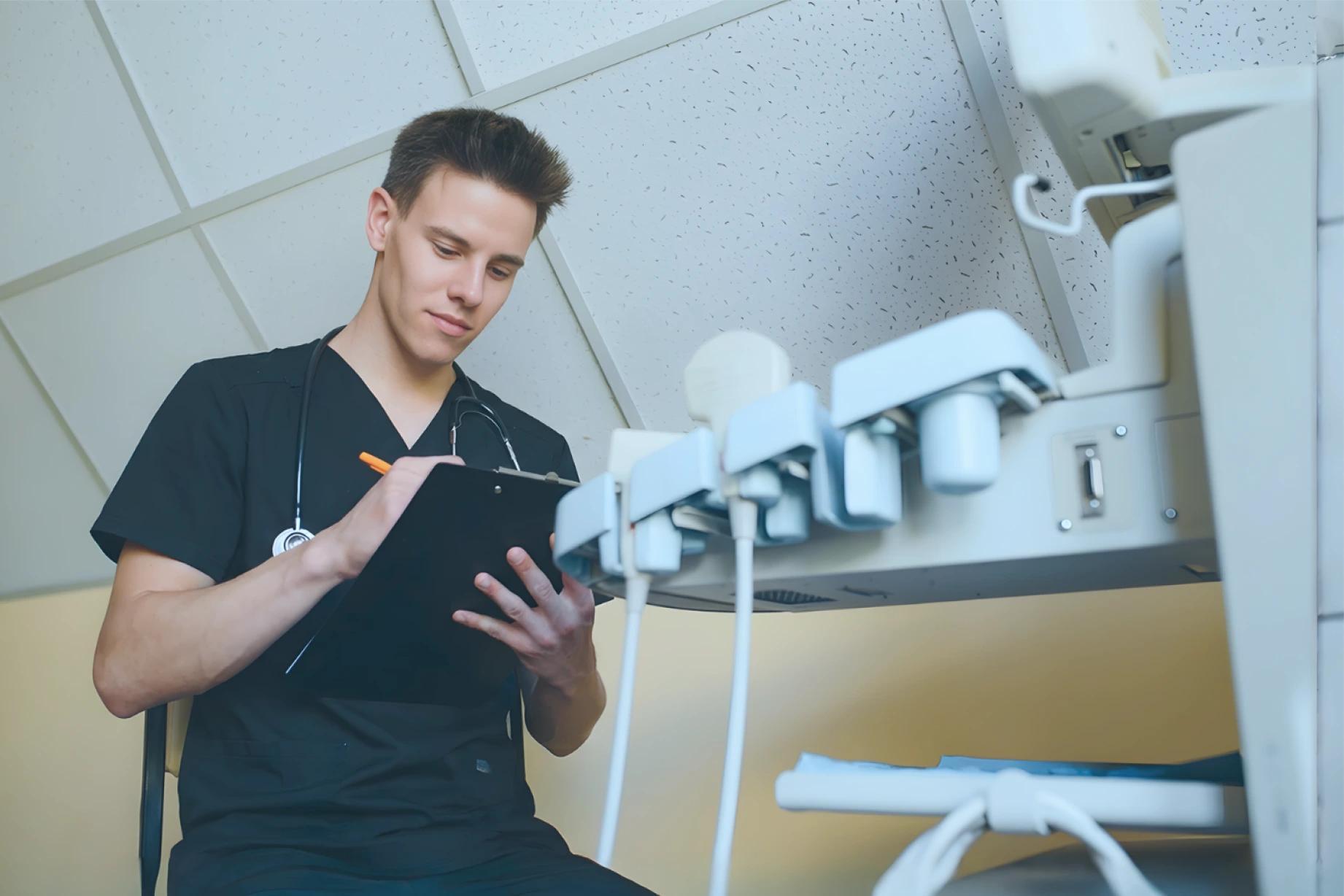 A medical professional in an ER environment reviewing patient notes on a clipboard.