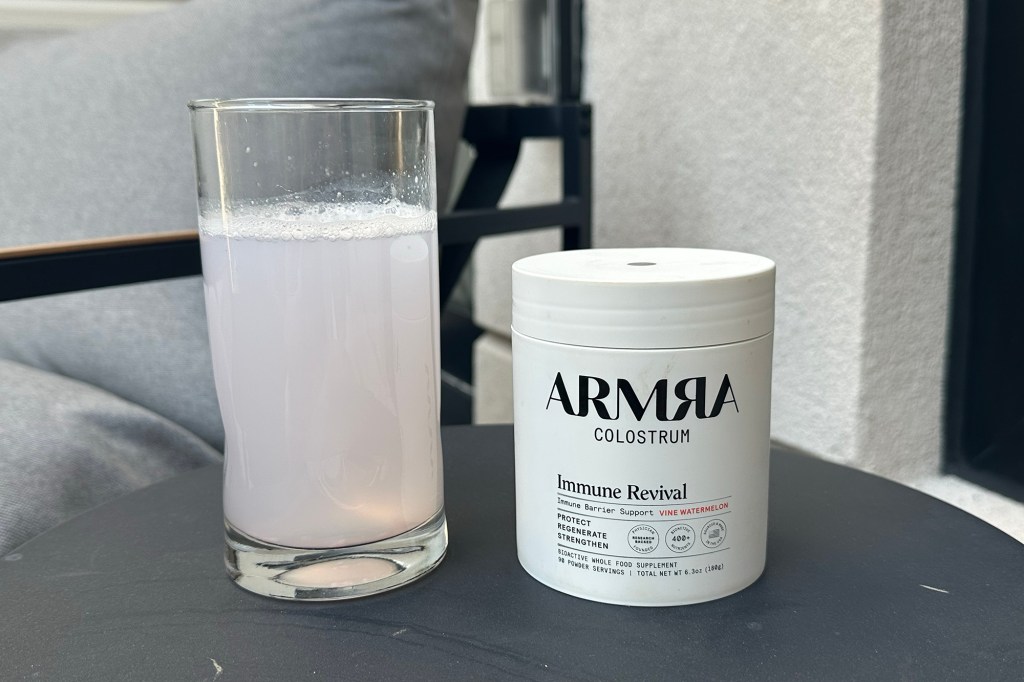 A jar of ARMRA Colostrum focusing on the brand labeling and quality assurance.