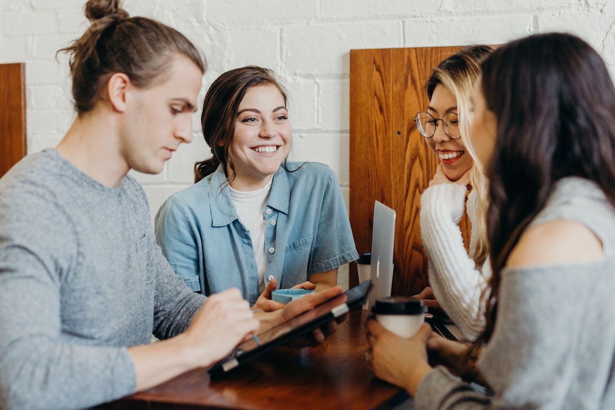 A diverse group of friends talking and walking outdoors in a bright, natural setting.